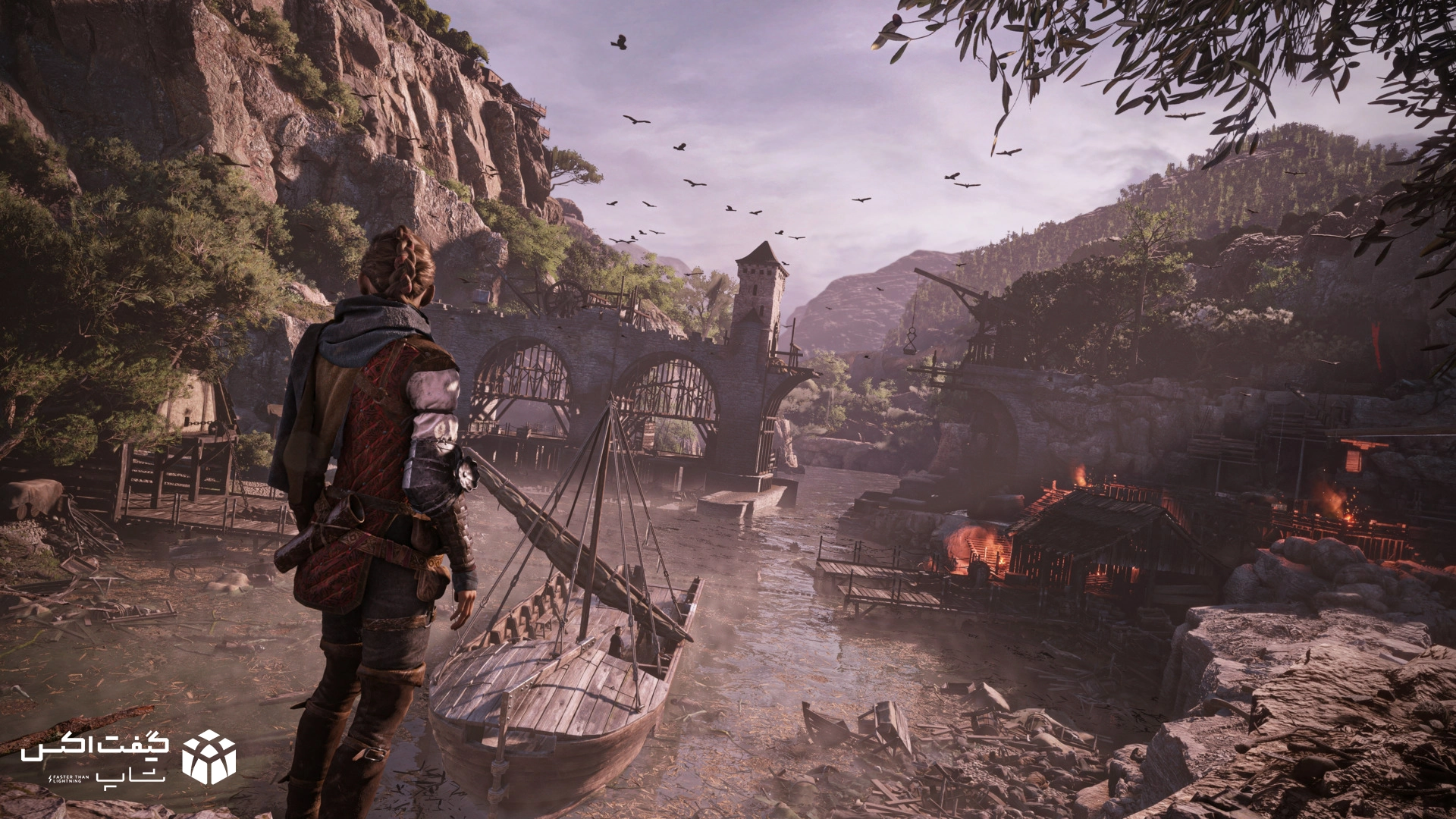 نمایی از شخصیت امیسیا در بازی A Plague Tale: Requiem در کنار رودخانه و روستای سوخته، با پس‌زمینه‌ای از پل سنگی و کوهستان در نور غروب