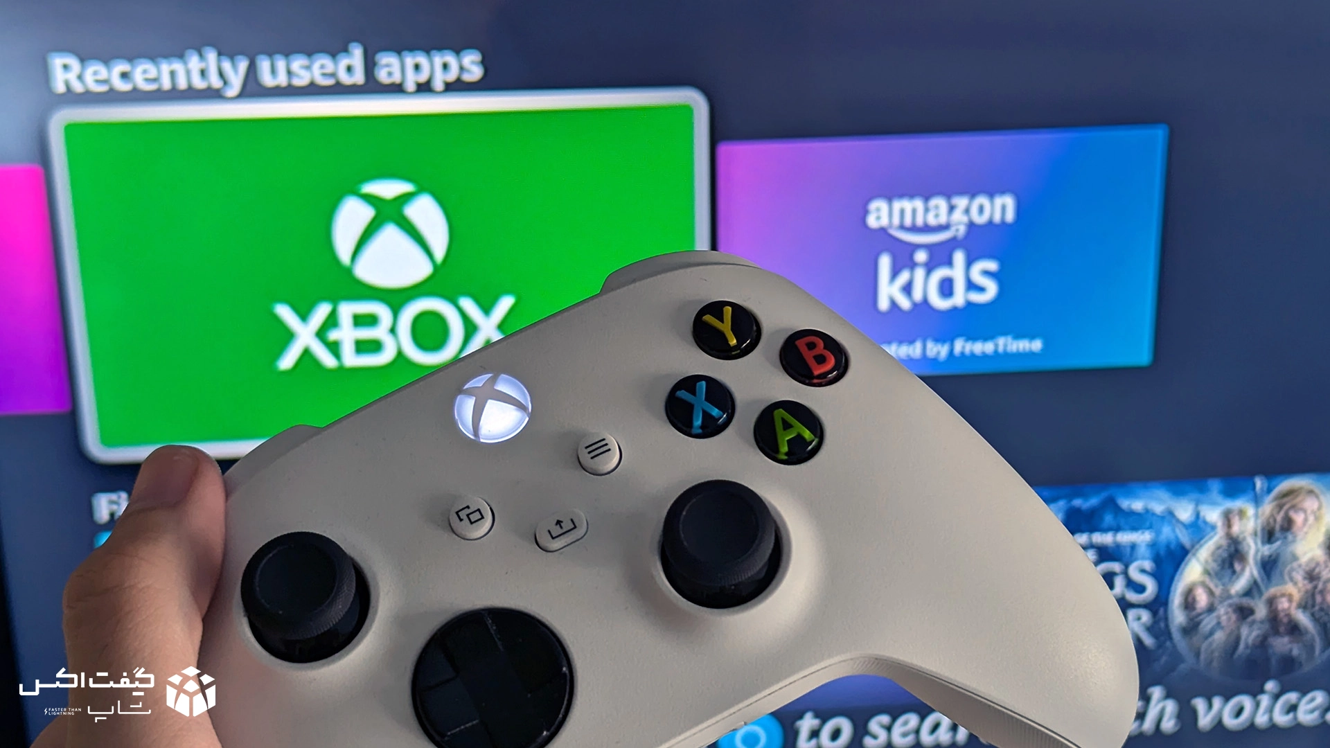 کنترلر سفید Xbox در دست کاربر مقابل صفحه نمایش اپلیکیشن Xbox، تصویر واقعی از تجربه گیمینگ
